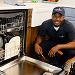 Grande Aire Services technician fixing refrigerator