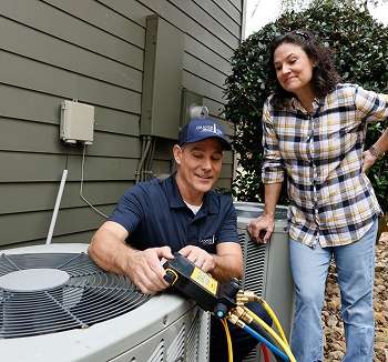 Grande Aire Services technician fixing outdoor HVAC unit