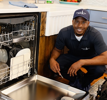 Grande Aire Services technician fixing refrigerator