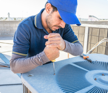 Grande Aire employee working on an AC condenser unit