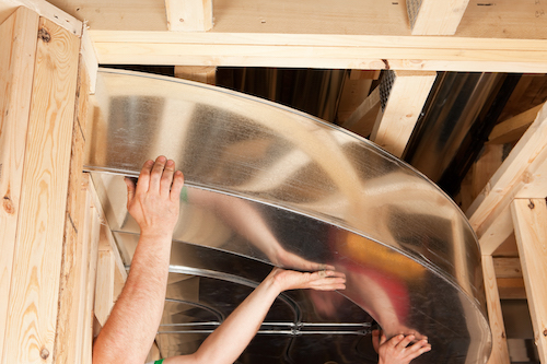 HVAC techs installing ductwork in new build