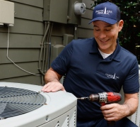 Grande Aire technician performing a seasonal tune-up on an AC unit